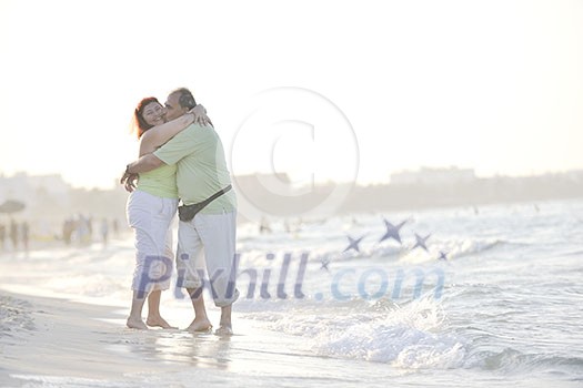 happy senior mature elderly people couple have romantic time on beach at sunset 