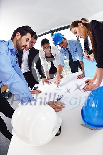 business people group on meeting and presentation in bright modern office with construction engineer architect and worker looking building model and blueprint planbleprint plans business people group on meeting and presentation in bright modern office with construction engineer architect and worker looking building model and blueprint planbleprint plans