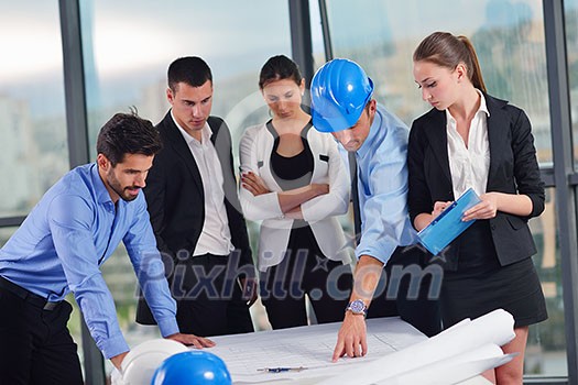 business people group on meeting and presentation in bright modern office with construction engineer architect and worker looking building model and blueprint planbleprint plans business people group on meeting and presentation in bright modern office with construction engineer architect and worker looking building model and blueprint planbleprint plans