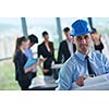 business people group on meeting and presentation  in bright modern office with construction engineer architect and worker looking building model and blueprint planbleprint plans