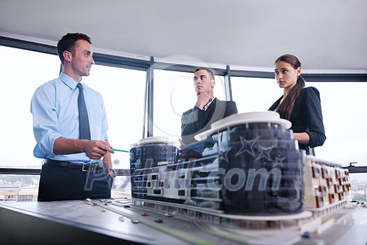 business people group on meeting and presentation  in bright modern office with construction engineer architect and worker looking building model and blueprint planbleprint plans