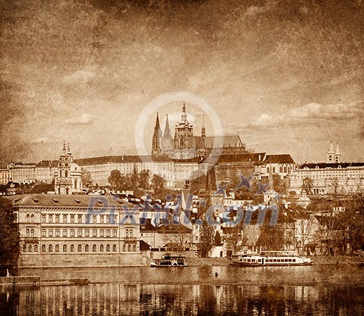 View of Charles bridge over Vltava river and Gradchany (Prague Castle) and St. Vitus Cathedral vintage sepia toned  with grunge texture overlaid