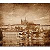 View of Charles bridge over Vltava river and Gradchany (Prague Castle) and St. Vitus Cathedral vintage sepia toned  with grunge texture overlaid