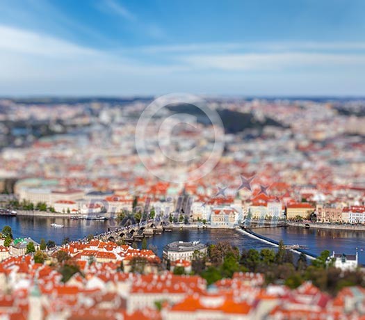 Aerial view of Charles Bridge over Vltava river and Old city from Petrin hill Observation Tower with tilt shift toy effect shallow depth of field. Prague, Czech Republic