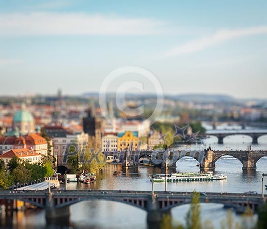 Travel Prague concept background - elevated view of bridges over Vltava river from Letna Park with tilt shift toy effect shallow depth of field. Prague, Czech Republic