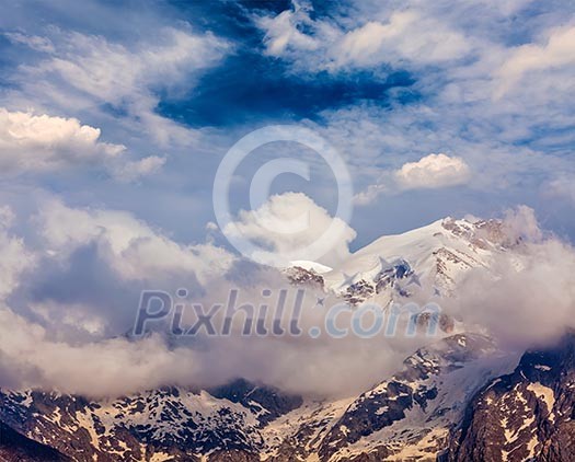 Snowcapped summit top of mountain in Himalayas in clouds. Himachal Pradesh, India