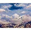 Snowcapped summit top of mountain in Himalayas in clouds. Himachal Pradesh, India