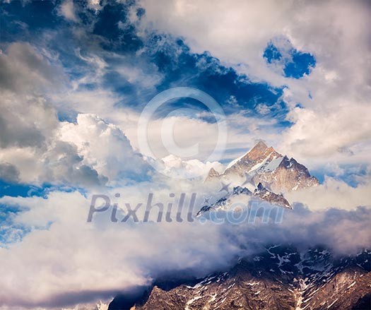 Snowcapped summit top of mountain in Himalayas in clouds. Himachal Pradesh, India