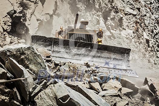 Bulldozer doing mountain road construction in Himalayas. Himachal Pradesh, India