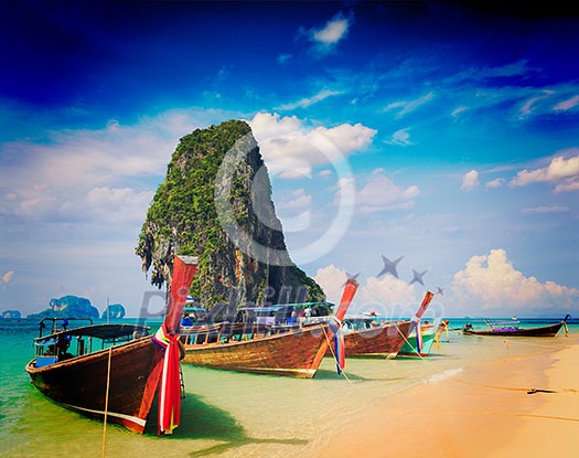 Vintage retro effect filtered hipster style travel image of long tail boat on tropical beach with limestone rock, Krabi, Thailand