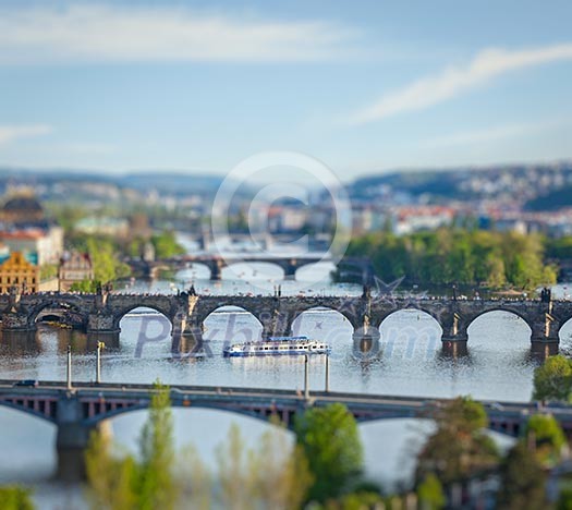 Travel Prague concept background - elevated view of bridges over Vltava river from Letna Park with tilt shift toy effect shallow depth of field. Prague, Czech Republic