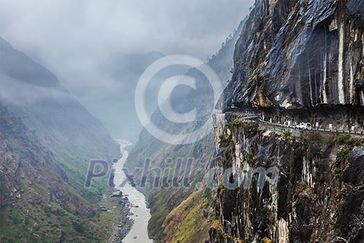 Car on road in Himalayas mountains above precipice