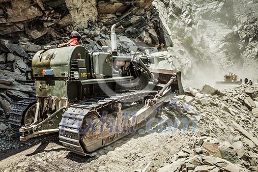 Bulldozer doing mountain road construction in Himalayas. Himachal Pradesh, India