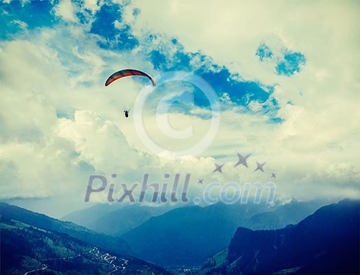 Vintage retro effect filtered hipster style travel image of freedom flight concept - paraplane in sky above Himalayas mountains