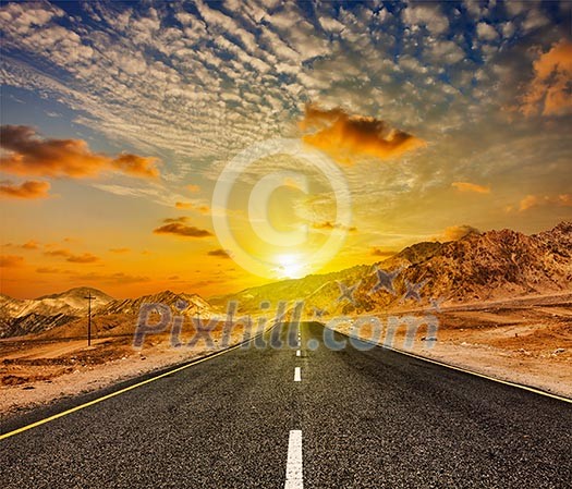 Travel forward concept background - road in Himalayas with mountains and dramatic clouds on sunset. Ladakh, Jammu and Kashmir, India Travel forward concept background - road in Himalayas with mountains and dramatic clouds on sunset. Ladakh, Jammu and Kashmir, India