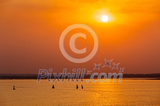 Yacht boats silhouettes in lake on sunset