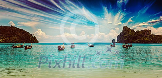 Vintage retro effect filtered hipster style travel image of long tail boat on beach on sunset on ebb. Thailand