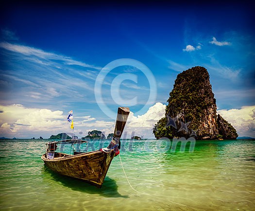Vintage retro effect filtered hipster style travel image of long tail boat on tropical beach Pranang and rock, Krabi, Thailand