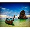 Vintage retro effect filtered hipster style travel image of long tail boat on tropical beach Pranang and rock, Krabi, Thailand