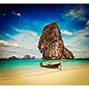 Vintage retro effect filtered hipster style travel image of long tail boat on tropical beach with limestone rock, Krabi, Thailand