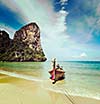 Vintage retro effect filtered hipster style travel image of long tail boat on tropical beach, Krabi, Thailand