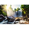 Tropical waterfall with sun rays in Cambodia