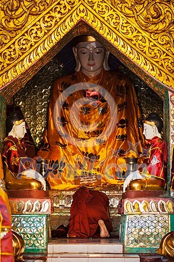 Buddhist monk praying in Shwedagon Paya pagoda. Yangon, Myanmar