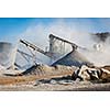 Industrial background - crusher rock stone crushing machine at open pit mining and processing plant for crushed stone, sand and gravel