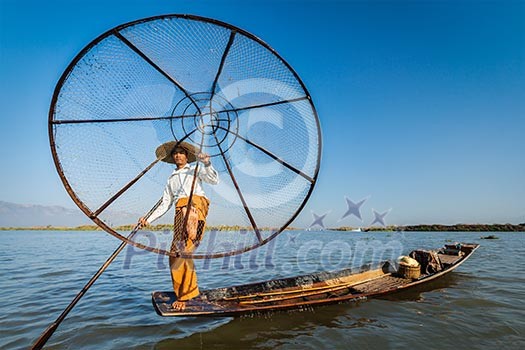 Myanmar travel attraction landmark - Traditional Burmese fisherman with fishing net at Inle lake in Myanmar famous for their distinctive one legged rowing style Myanmar travel attraction landmark - Traditional Burmese fisherman with fishing net at Inle lake in Myanmar famous for their distinctive one legged rowing style