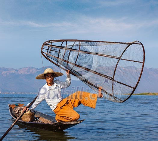 Myanmar travel attraction landmark - Traditional Burmese fisherman with fishing net at Inle lake in Myanmar famous for their distinctive one legged rowing style Myanmar travel attraction landmark - Traditional Burmese fisherman with fishing net at Inle lake in Myanmar famous for their distinctive one legged rowing style