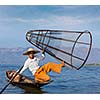 Myanmar travel attraction landmark - Traditional Burmese fisherman with fishing net at Inle lake in Myanmar famous for their distinctive one legged rowing style