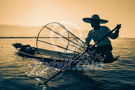 Myanmar travel attraction landmark - Traditional Burmese fisherman at Inle lake, Myanmar famous for their distinctive one legged rowing style Myanmar travel attraction landmark - Traditional Burmese fisherman at Inle lake, Myanmar famous for their distinctive one legged rowing style
