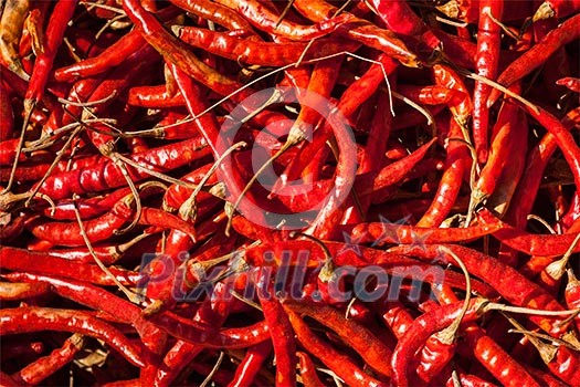 Red spicy chili peppers at asian market close up texture background