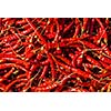 Red spicy chili peppers at asian market close up texture background