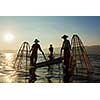 Myanmar travel attraction landmark - three traditional Burmese fishermen at Inle lake, Myanmar famous for their distinctive one legged rowing style