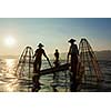 Myanmar travel attraction landmark - three traditional Burmese fishermen at Inle lake, Myanmar famous for their distinctive one legged rowing style