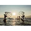 Myanmar travel attraction landmark - three traditional Burmese fishermen at Inle lake, Myanmar famous for their distinctive one legged rowing style