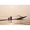 Myanmar travel attraction landmark - Traditional Burmese fisherman with fishing net at Inle lake in speeding motor boat