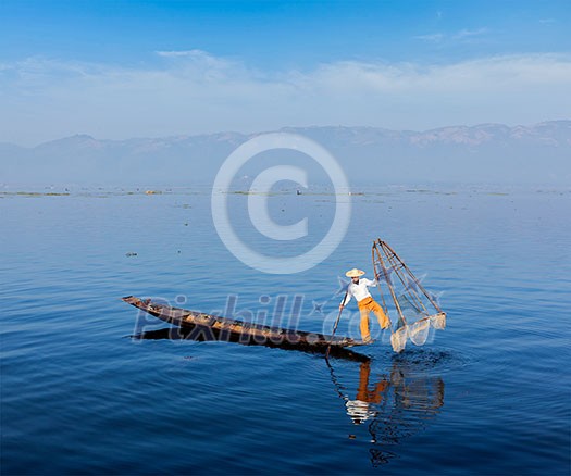 Myanmar travel attraction landmark - Traditional Burmese fisherman at Inle lake, Myanmar famous for their distinctive one legged rowing style Myanmar travel attraction landmark - Traditional Burmese fisherman at Inle lake, Myanmar famous for their distinctive one legged rowing style
