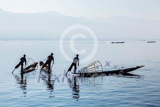 Myanmar travel attraction landmark - Traditional Burmese fisherman at Inle lake, Myanmar famous for their distinctive one legged rowing style Myanmar travel attraction landmark - Traditional Burmese fisherman at Inle lake, Myanmar famous for their distinctive one legged rowing style