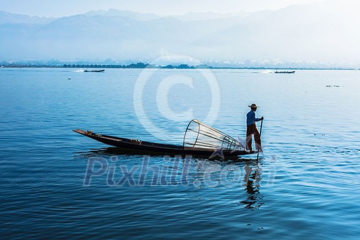 Myanmar travel attraction landmark - Traditional Burmese fisherman at Inle lake, Myanmar famous for their distinctive one legged rowing style