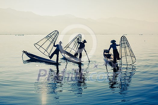 Myanmar travel attraction landmark - Traditional Burmese fisherman at Inle lake, Myanmar famous for their distinctive one legged rowing style Myanmar travel attraction landmark - Traditional Burmese fisherman at Inle lake, Myanmar famous for their distinctive one legged rowing style
