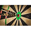 Success hitting target aim goal achievement concept background - three darts in bull's eye close up