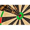 Success hitting target aim goal achievement concept background - three darts in bull's eye close up