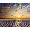 Wooden surface of planks pier under sunset dramatic sky