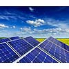 Solar power generation technology, green alternative energy and environment protection ecology business concept background -  solar battery panels in summer spring blooming rural meadow field with blue sky