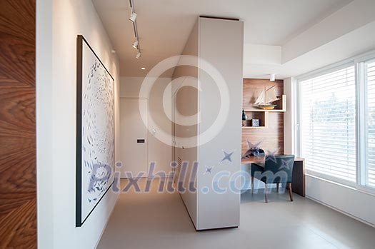 Light home office corner by large windows Light home office corner by large windows