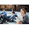 Portrait of a sleek young woman, using laptop computer, being pensive in urban/city context (shallow DOF; color toned image)