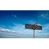Signpost with directional signs in sky with clouds