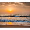 Sunrise on beach with dramatic sky